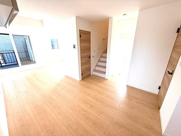 リビングは明るい日差しが差し込む空間です。ナチュラルな木目調の床が温かみを感じさせます。階段や扉の配置もシンプルで使いやすい設計となっています。