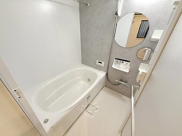 浴室全体が明るく清潔感のある空間です。壁面には大きなミラーと収納棚が付いており使い勝手も配慮されています。浴槽はゆったりとした設計で毎日のリフレッシュに適しています。