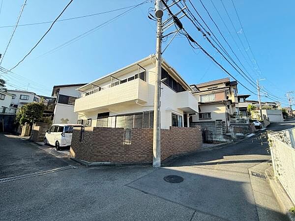 角地に位置し開放感があります。前面道路が広く車での出入りもしやすいです。周辺には住宅が多く落ち着いた街並みが広がっています。建物の外観も明るい印象です。
