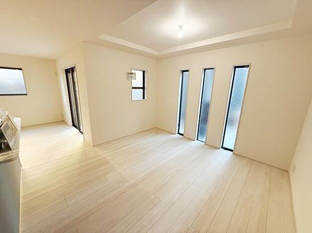 リビングには縦長の窓が並び室内にやわらかな光を取り入れています。明るい色調のフローリングで開放感があります。天井のデザインが空間にアクセントを加えています。室内全体の統一感が感じられます。