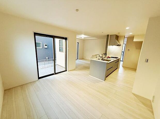 明るいフローリングが空間を広く見せます。キッチンとリビングが繋がるレイアウトです。大きな窓から自然光がしっかり差し込みます。シンプルな内装が家具の配置をしやすくします。開放感を感じられるリビングです。