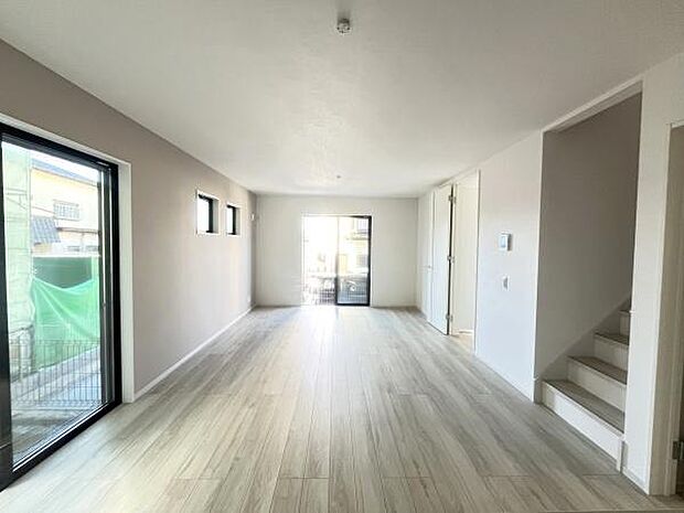 大きな窓から自然光がたっぷり差し込むリビングです。明るく開放的な印象を持ち合わせています。シンプルな内装で様々なインテリアと調和しやすい雰囲気です。床材の色合いが落ち着いた空間を演出しています。