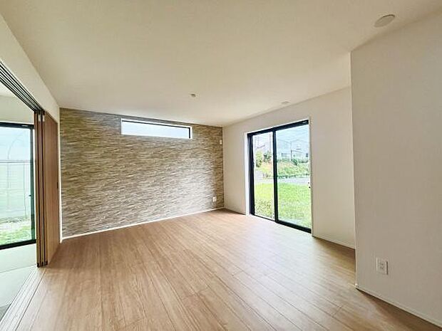 リビングは大きな窓があり光がたっぷり入る明るい空間です。木目調のフローリングが落ち着いた雰囲気を演出しています。アクセントクロスが上品な印象を与え開放感があります。