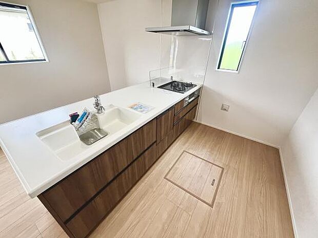 シンプルで使いやすいレイアウトのキッチンです。窓からの光が明るく自然な雰囲気を感じられます。調理や片付けがしやすいスペースが確保されています。収納も充実しておりすっきりとしています。