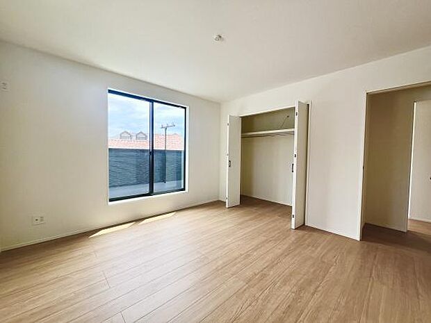 大きな窓から光が差し込む明るい室内です。収納スペースがすっきりと備わっており衣類や荷物の整理に役立ちます。フローリングの床が室内全体をシンプルで清潔感のある印象に仕上げています。