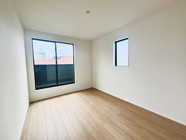大きな窓から光が差し込む洋室です。明るく開放感のある空間が魅力です。ナチュラルな色合いのフローリングが印象的です。壁や天井はシンプルなデザインで家具の配置もしやすいです。