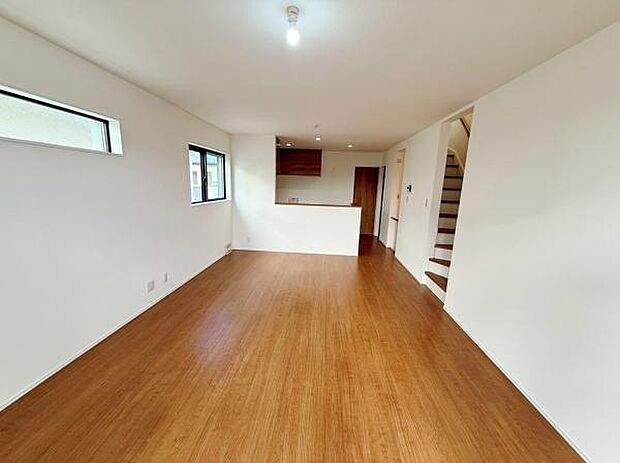 リビングは明るい色合いのフローリングで開放感があります。二面採光の設計で室内に自然光を取り入れやすいです。壁や天井の白さが全体を爽やかに演出しています。