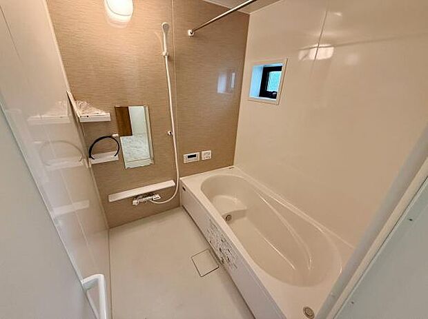 清潔感のある白を基調としたバスルームです。小窓から採光があり明るい空間となっています。壁付けの棚やミラーも設置されており使いやすさも考慮されています。ゆったりとした浴槽でリフレッシュできます。