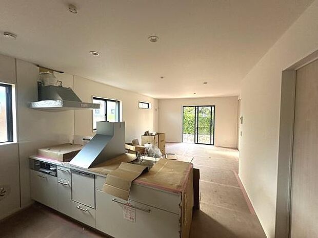 大きな窓から自然光がたくさん入るリビングです。キッチンと一体感のある空間が広がっています。落ち着いた雰囲気と明るさが感じられます。収納スペースも確保されています。開放感のあるレイアウトとなっています。