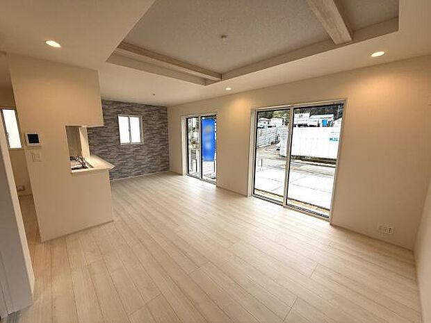 広々としたリビング空間が明るさを引き立てます。大きな窓からたっぷりと自然光が差し込みます。白を基調とした床材が室内全体を開放的に演出します。天井のアクセント梁がデザイン性を高めています。