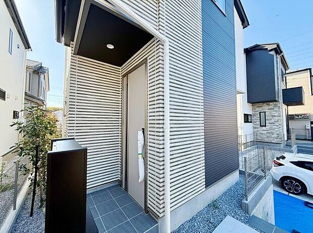 スタイリッシュな外観が印象的な玄関です。アプローチ部分も広く開放感があります。シンプルなデザインで全体的に落ち着いた雰囲気が感じられます。門柱やポストもまとまっていてすっきりした印象を与えます。