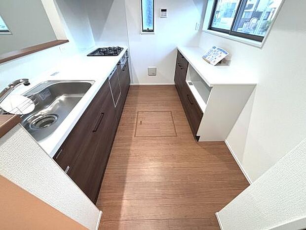 明るい光が差し込む窓に面したキッチンです。作業スペースが広く取られており収納も充実しています。ガスコンロとシンクがバランス良く配置されています。床下収納もありすっきりとした空間が魅力です。