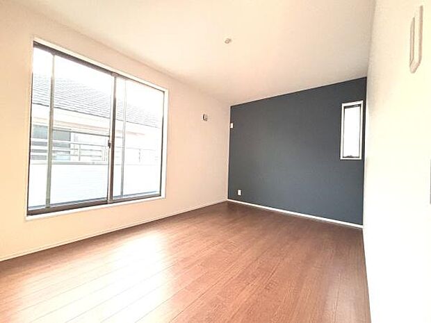 広々とした洋室が特徴的です。大きな窓からたっぷりと光が取り込めます。アクセントクロスがお部屋の印象を引き締めています。シンプルな内装でインテリアのアレンジも楽しめます。全体的に落ち着いた雰囲気です。