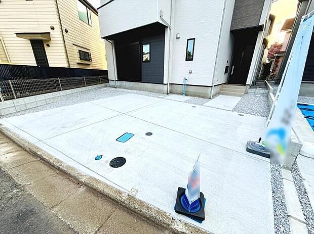 駐車場は幅広く設計されており出入りもスムーズです。地面はコンクリート仕様で雨にも強くメンテナンスもしやすい状態です。住まいの正面にゆとりあるスペースが確保され使い勝手が良好です。