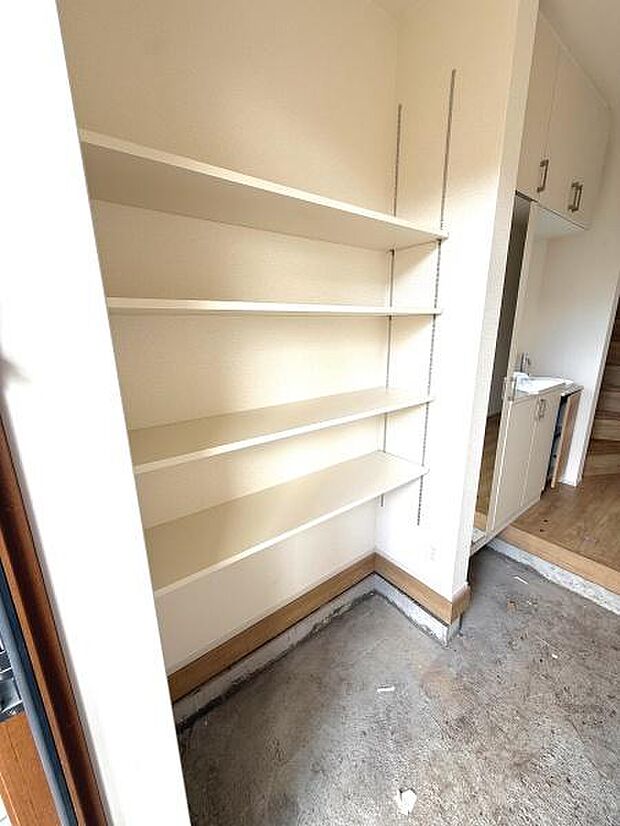 壁面にすっきりと収まる収納棚が設置されています。高さ調整がしやすく使い勝手の良い設計です。収納スペースが豊富なので多様なアイテムの整理に役立ちます。