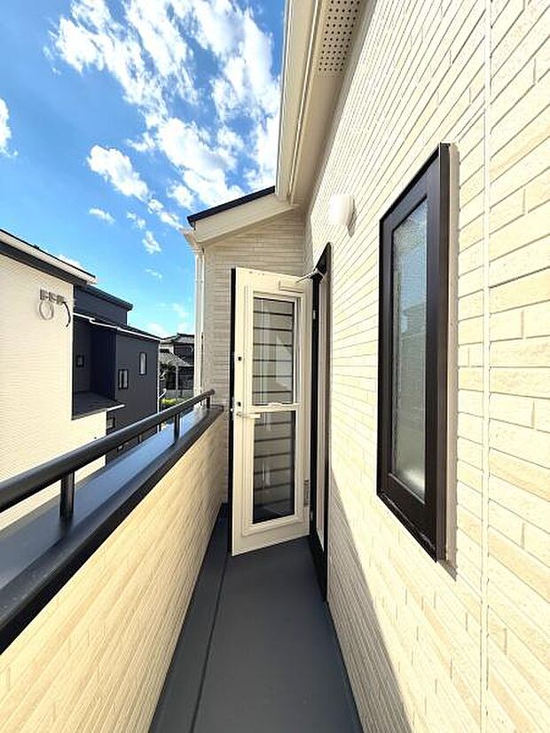 明るい日差しが差し込むバルコニーです。奥行きがあり開放感のある空間になっています。外壁の色合いが清潔感を演出しています。上階からの眺望も楽しめる設計です。扉部分も広く使い勝手が良好です。