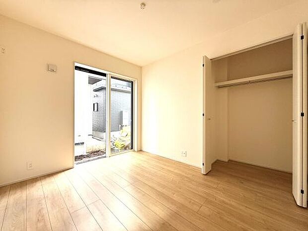 明るい光が差し込む洋室です。収納力のあるクローゼットが備わっています。ナチュラルなフローリングが心地よい空間を演出します。スライドドアからお庭へのアクセスも便利です。ゆとりのある広さが魅力です。