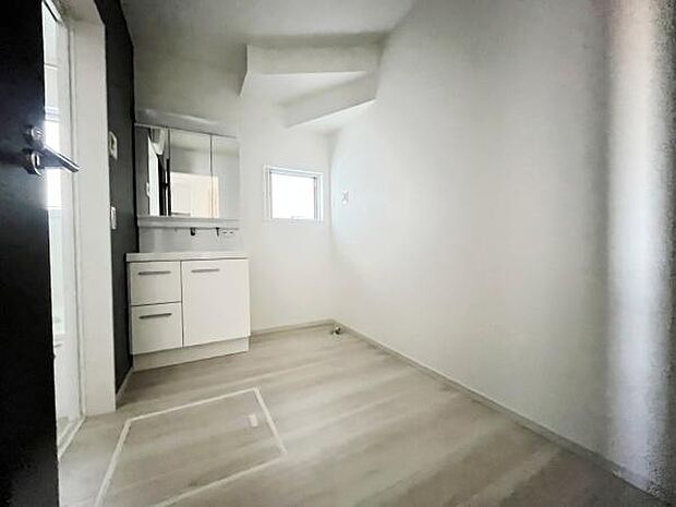 洗面台がシンプルで清潔感のあるデザインです。窓が設けられているため自然光を感じられます。広さがあり使いやすい空間です。白を基調とした内装が明るい印象を与えます。