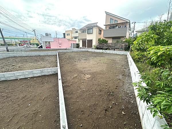 整形された区画が印象的な現地土地写真です。周辺には住宅が整然と建ち並び落ち着いた環境が広がっています。道路へのアクセスも確認できる立地です。ゆとりある敷地で多様なプランに対応しやすい形状です。