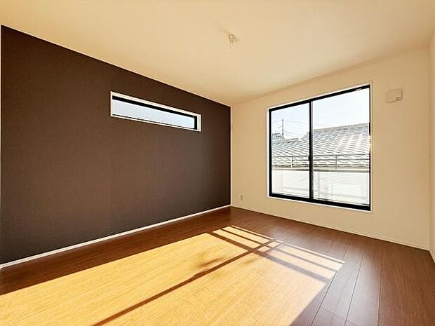 リビングには大きな窓があり明るい光がたっぷり入ります。アクセントクロスが空間にモダンな印象を与えています。木目調の床が温かみを感じさせ落ち着いた雰囲気です。窓からの眺めも良好で開放感があります。