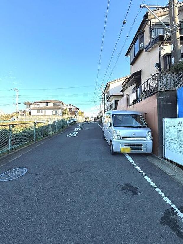 現地周辺は開放感のある通りが特徴です。青空が広がるエリアで前面道路も見通しが良いです。近隣は住宅が並び落ち着いた雰囲気の街並みが感じられます。道路幅もしっかり確保されています。