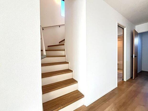 明るい色合いの壁と木目調のフローリングが調和した空間です。階段部分には窓があり自然光が差し込みます。廊下は無駄のないシンプルな造りです。どんなインテリアとも相性が良い内装です。