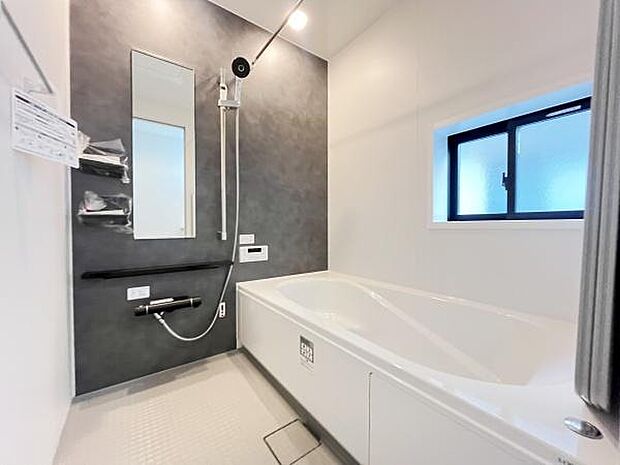 清潔感のあるバスルームが魅力です。大きなミラーとシャワーは使いやすさを重視した設計になっています。窓からは自然な光が入り明るい空間です。浴槽の形状もゆったりとしたデザインです。