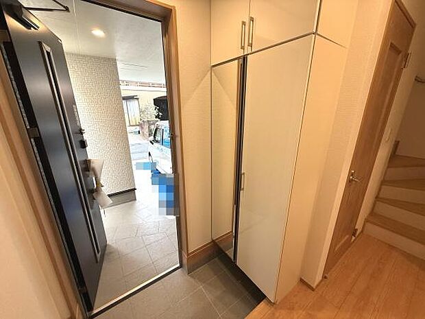 明るい玄関スペースが広がっています。大きめの収納が設置されておりすっきりとした印象です。タイル張りの床面でお手入れも簡単です。家全体に清潔感が感じられます。