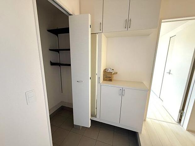 広々とした玄関スペースが印象的です。高さのある収納棚が備え付けられており整理整頓がしやすい構造です。室内に明るい光が差し込み清潔感のある空間となっています。