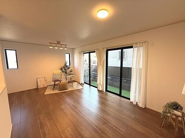 リビングは明るい日差しが差し込む大きな窓が特徴です。広々としたフローリングで開放感があります。白を基調とした壁が室内をすっきりとした印象にしています。