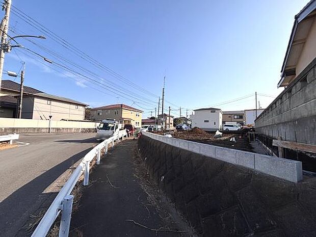 前面道路が広く車の出し入れがしやすい環境です。周辺には住宅が建ち並び整然とした印象があります。舗装された道路と歩道がしっかり分かれており安心感があります。現地は陽当たりが良く空が広く感じられます。