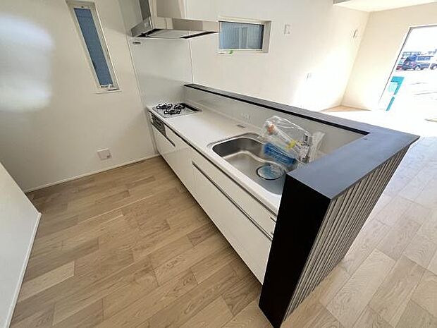 シンプルなデザインが空間をすっきりと見せます。カウンター付きで料理の際にも便利です。窓から自然な光が入る明るいキッチンです。作業スペースがしっかり確保されています。収納も豊富で使い勝手が良い仕様です。