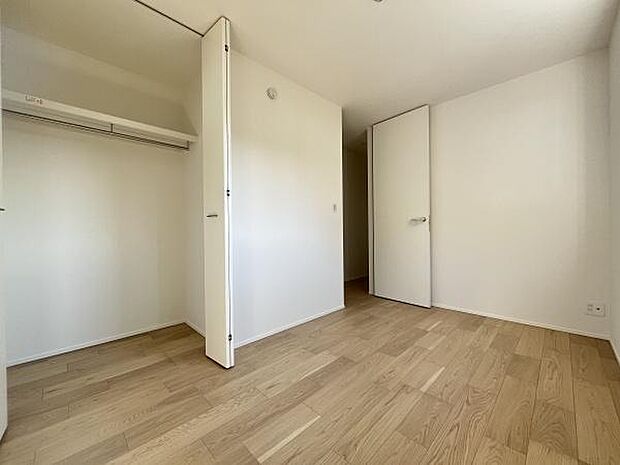 クローゼット付きの収納スペースがあるお部屋です。ナチュラルなフローリングが明るい印象を与えます。壁が白くシンプルな内装が特徴です。奥行きのある収納で整理整頓しやすい空間です。