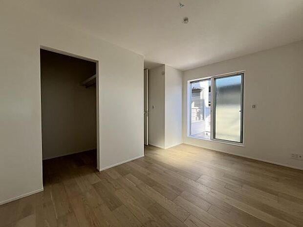 洋室は二面採光で明るく床や壁の色合いが落ち着いた雰囲気を感じさせます。収納スペースがしっかりと確保されています。窓から外の景色を楽しめる設計です。室内はすっきりとした印象です。