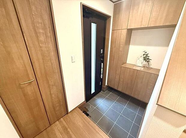 玄関スペースが広く収納がしっかり確保されています。木目調のデザインが温かみを感じさせます。シンプルな内装でお手入れもしやすい玄関です。落ち着いた雰囲気の空間が広がっています。