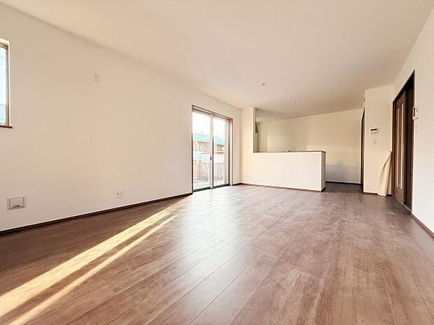 明るい日差しが差し込むリビングは広々とした空間が魅力です。大きな窓が開放感を演出し床材の色合いが落ち着いた雰囲気を生み出しています。キッチンへの動線もスムーズで使いやすさがあります。