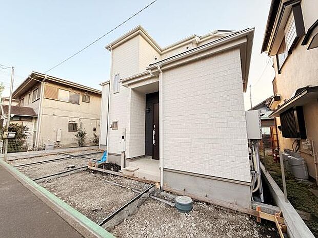 シンプルな外観が際立つ建物です。前面道路に面していて住まいへのアクセスが便利です。周囲には住宅が建ち並ぶ落ち着いた雰囲気となっています。敷地内も広がりを感じられます。清潔感のある現地写真です。
