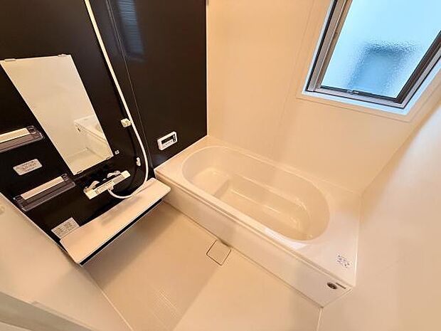 清潔感のあるシンプルなバスルームです。窓があり適度に換気が可能です。ブラックのアクセントパネルが空間を引き締めています。使いやすい洗い場と浴槽が魅力です。