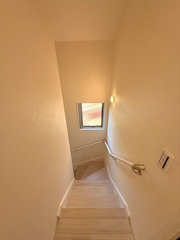 明るい色合いの階段が空間全体をすっきりとした印象にしています。手すりが設置されており移動の際も安心感があります。窓からの自然光が階段をやさしく照らしてくれます。清潔感のある仕上がりが魅力的です。