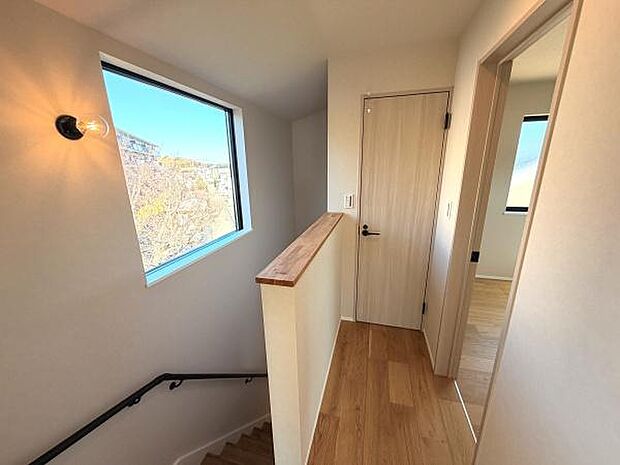 階段ホールには大きな窓があり自然光がしっかり差し込みます。明るい木目調の床が空間を引き立てています。シンプルな装飾で落ち着いた雰囲気です。各部屋へのアクセスもスムーズです。