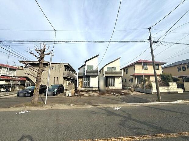 ゆったりとした前面道路が特徴で車の出し入れも安心です。建物の個性的な外観が印象的な現地写真です。周囲には落ち着いた住宅が並び開放感のある街並みが広がっています。