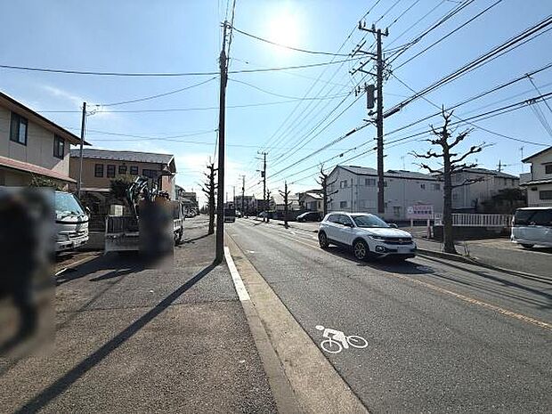 前面道路は広々としており車や自転車の通行がしやすい印象です。道路沿いには整然とした住宅が並び街並みも落ち着いています。道路に自転車レーンの表示もあり利便性の高さが伺えます。