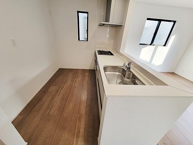 キッチンは窓があり採光がしっかりと確保されています。ワークトップが広めで作業がしやすい設計です。シンプルなデザインで清潔感があります。換気にも配慮されているレイアウトです。