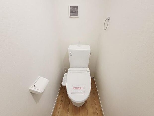 清潔感のあるシンプルなトイレです。換気扇付きで空気の入れ替えも配慮されています。床には木目調の素材が使われており落ち着いた雰囲気です。スペースもしっかりと確保されています。