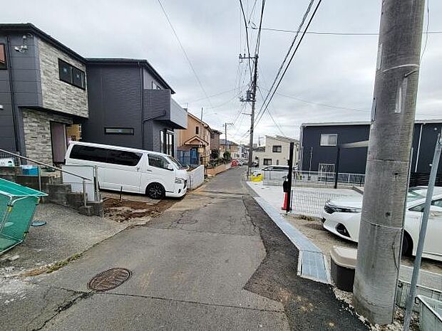 前面道路がしっかりと整備されており周囲にはさまざまな住宅が建ち並んでいます。道幅もあり車両の出入りもスムーズに行えます。住環境の様子が分かりやすい現地写真です。