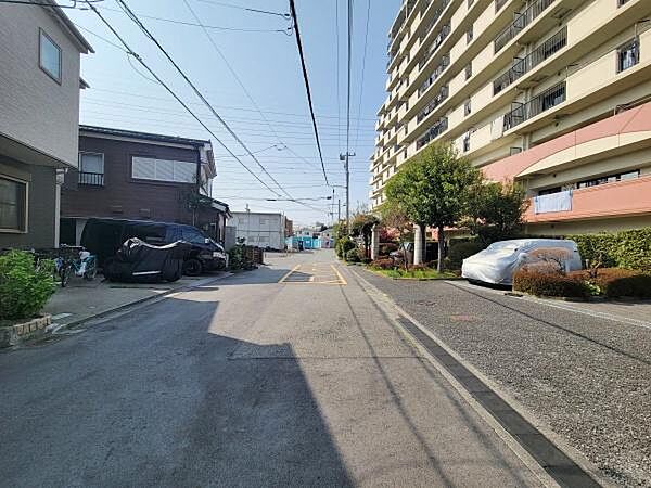 道幅が広く車の出し入れがしやすい道路環境です。周辺には住宅やマンションが立ち並び落ち着いた雰囲気が感じられます。舗装も丁寧で自転車などの利用にも便利です。通り沿いには緑もあり環境が整っています。