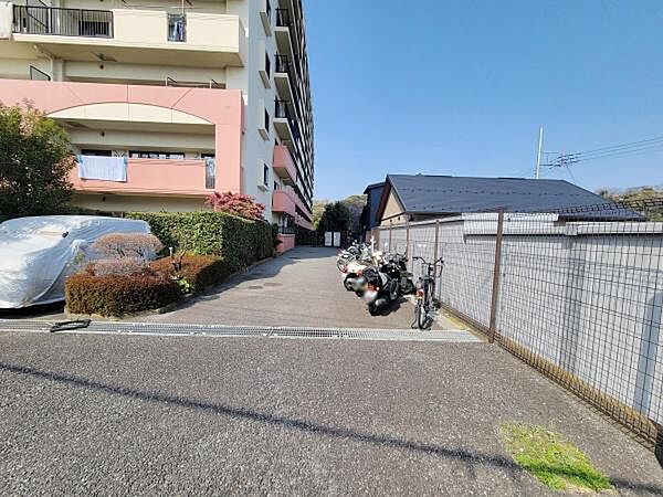 敷地内にバイクや自転車の駐輪スペースが確保されています。植え込みが整備されており管理の行き届いた共用部分が感じられます。アパートの外観も明るい印象です。フェンスで境界が明確になっています。