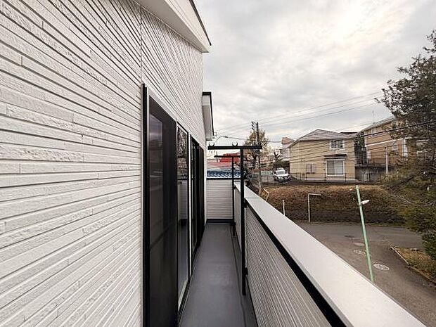 シンプルなデザインの外壁が際立つバルコニーです。しっかりとした手すりがあり安心して利用できます。外の景色を楽しみながら開放感を味わえます。複数の窓から光が差し込みバルコニー全体が明るい印象です。