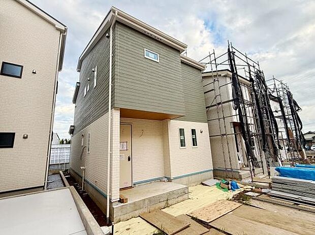 シャープな外観デザインが特徴的な新築住宅です。窓の配置や外壁のツートーンカラーが印象的です。玄関部分にはしっかりとした屋根があり雨の日も安心です。