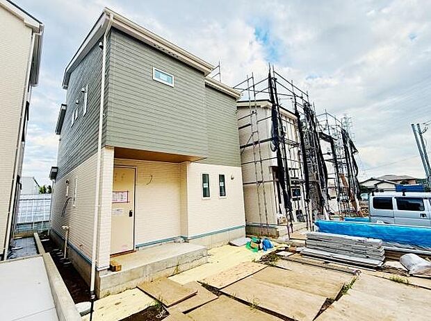 シンプルな外観が特徴的な新築戸建です。周囲には新しい住宅が建ち並び落ち着いた雰囲気となっています。玄関までのアプローチもすっきりとした印象です。